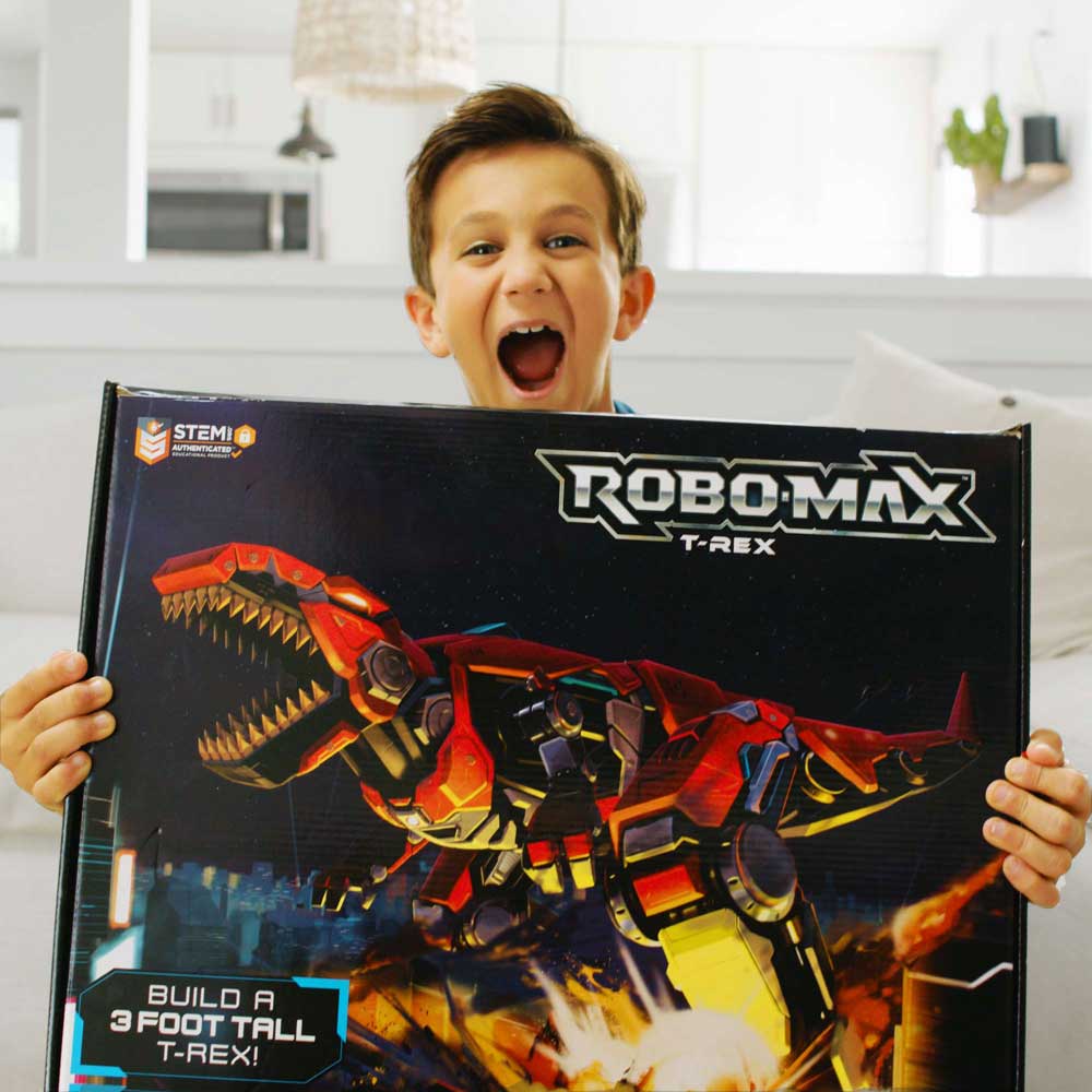 A very excited boy holds the retail box containing the Robo-Max T-Rex toy.