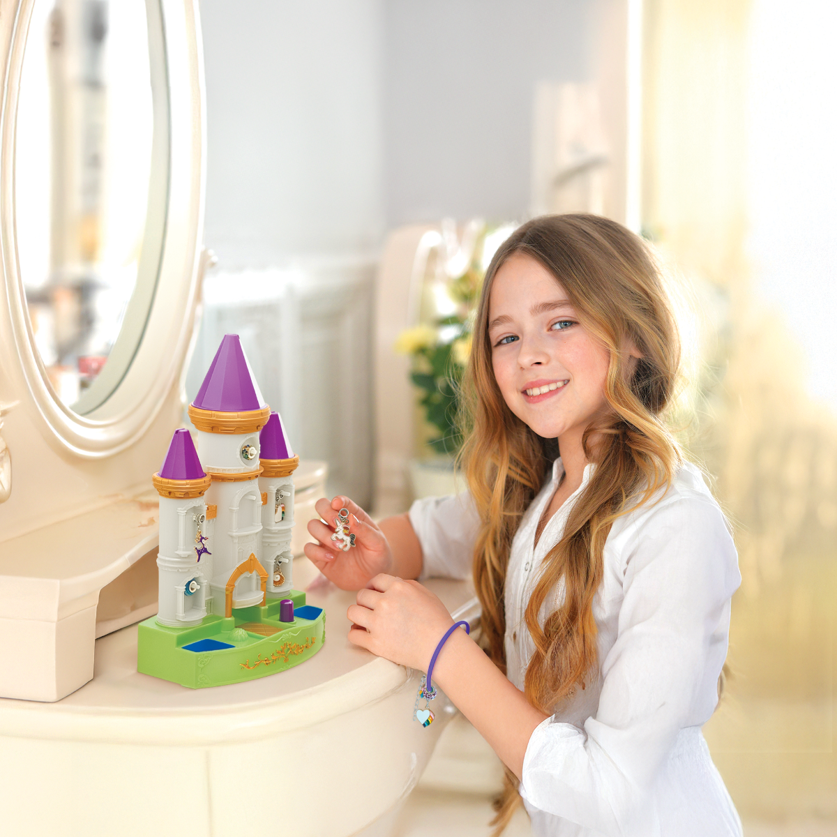 Young girl playing with a toy castle on a vanity table.