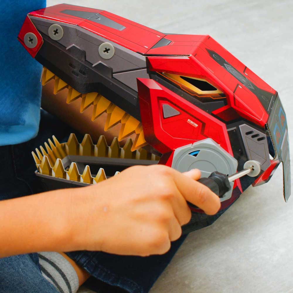 A child's hand turning the custom screwdriver (included) while assembling the Robo-Max T-Rex toy. 
